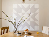 Dining room with a geometric tile wall and a table set with bread and fruit.