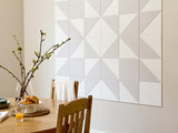 Dining area with geometric wall tiles and a wooden table.