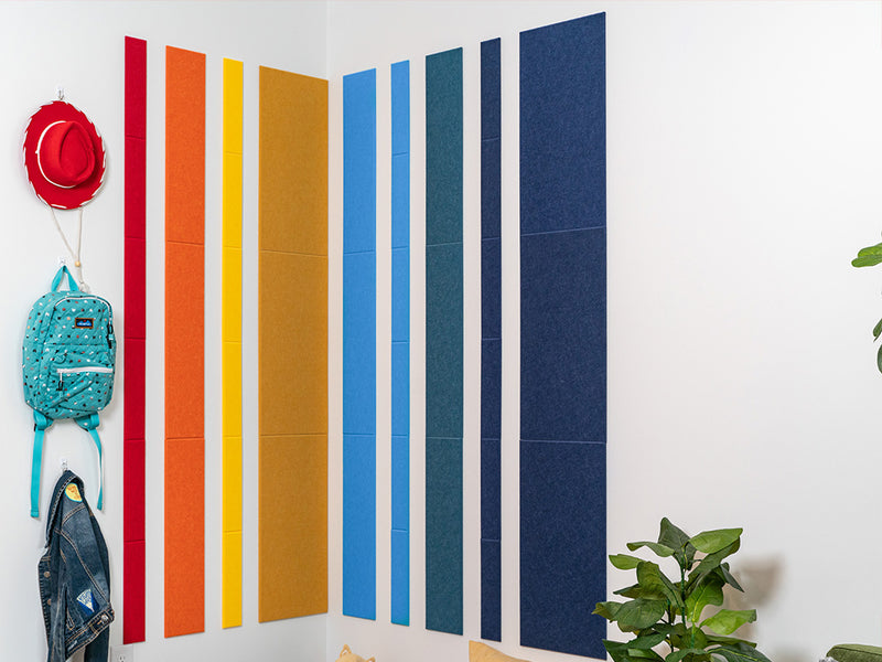 Rainbow felt wall tiles in corner with kids decor.