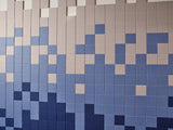 Grid of small square tiles in shades of blue, cream, and taupe arranged in a pixelated pattern.