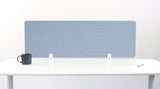 Blue desk divider with geometric line pattern, mounted on white desk with black mug and supplies.