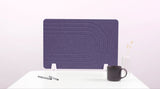 Purple desk divider with geometric arc pattern, positioned on white desk with mug and pen holder.