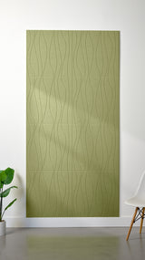 Aloe green Felt Right 4’ x 8’ PET felt panel with flowing lines engraved into the material against a white wall. A plant and chair are in the foreground.