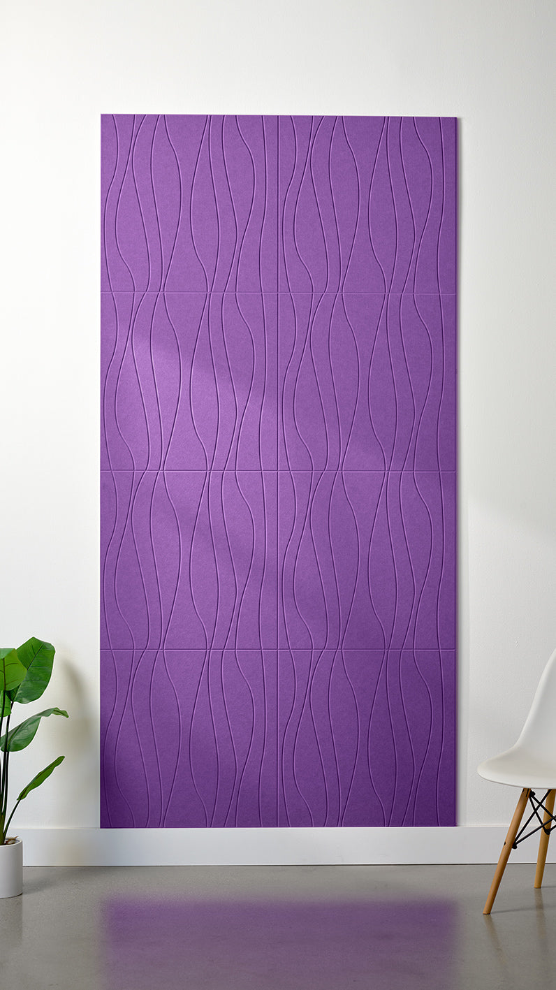 Lavender Felt Right 4’ x 8’ PET felt panel with flowing lines engraved into the material against a white wall. A plant and chair are in the foreground.