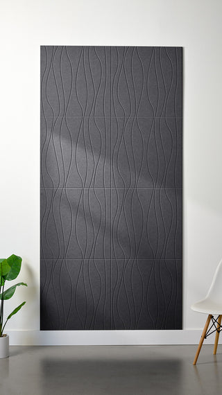 Grey Felt Right 4’ x 8’ PET felt panel with flowing lines engraved into the material against a white wall. A plant and chair are in the foreground.