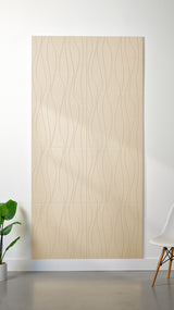 Beige Felt Right 4’ x 8’ PET felt panel with flowing lines engraved into the material against a white wall. A plant and chair are in the foreground.