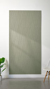 Sage Felt Right 4’ x 8’ PET felt panel with flowing lines engraved into the material against a white wall. A plant and chair are in the foreground.