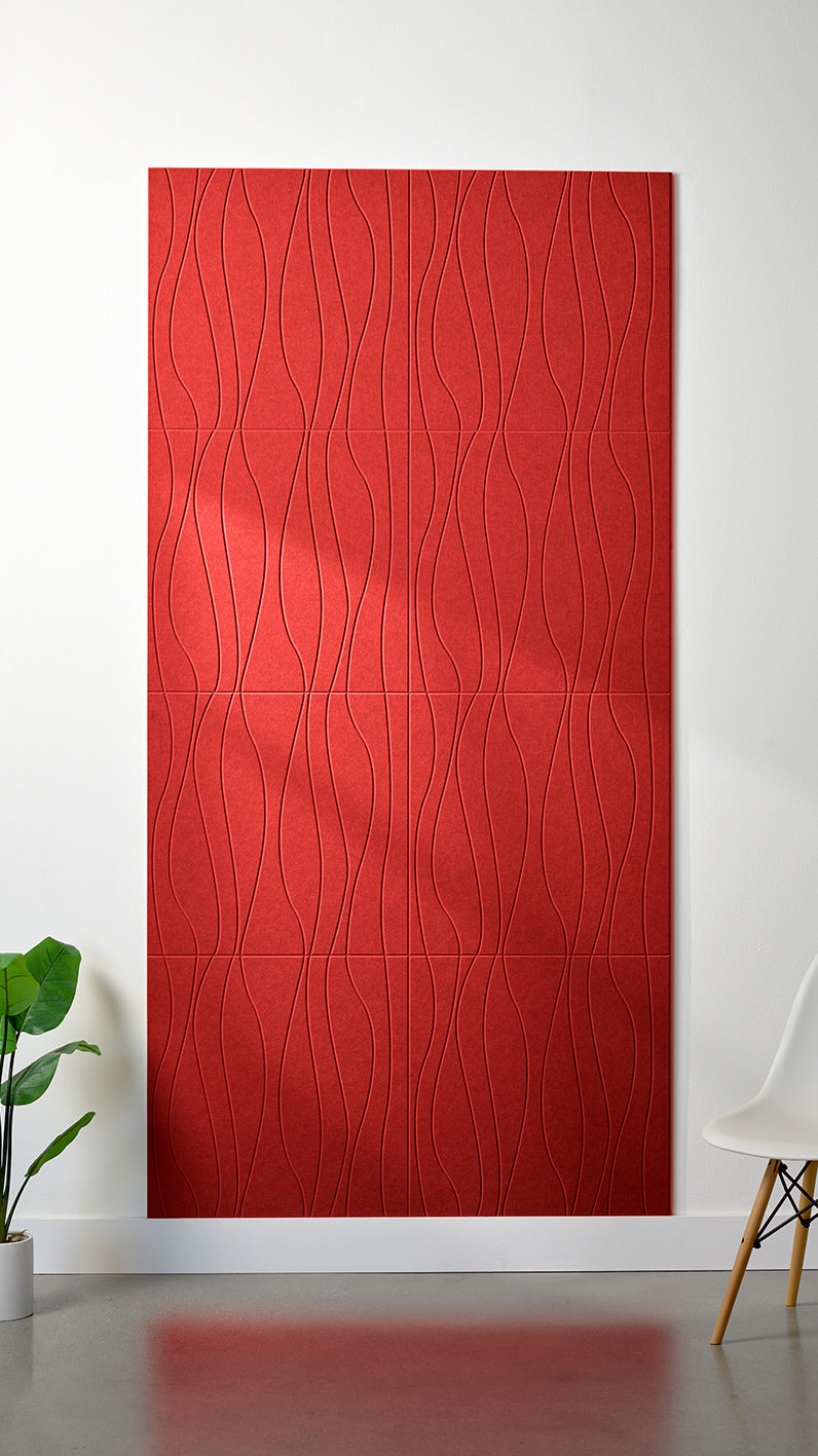 Red Felt Right 4’ x 8’ PET felt panel with flowing lines engraved into the material against a white wall. A plant and chair are in the foreground.