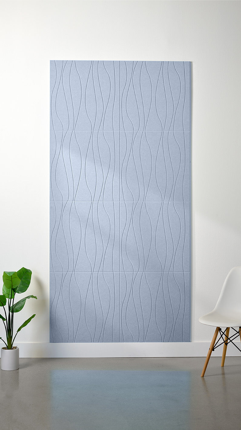 Light blue felt sheet with wavy line engraving pattern displayed on wall.