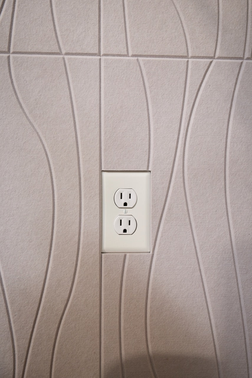 Felt Right River Ivory tiles are cut around a white electrical outlet