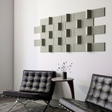 Angled shot of green dimensional wall art above two black chairs