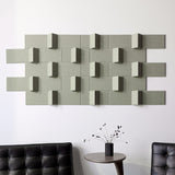 Green dimensional wall art above black chair.