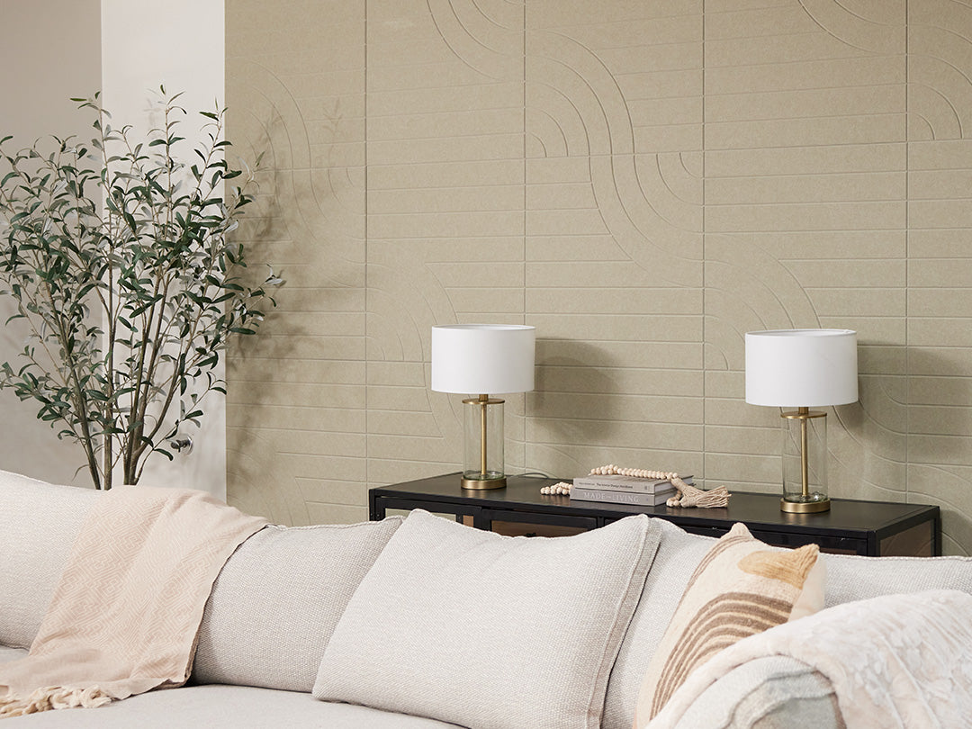 Felt Right acoustic panels in light sage green on wall behind couch next to a plant.