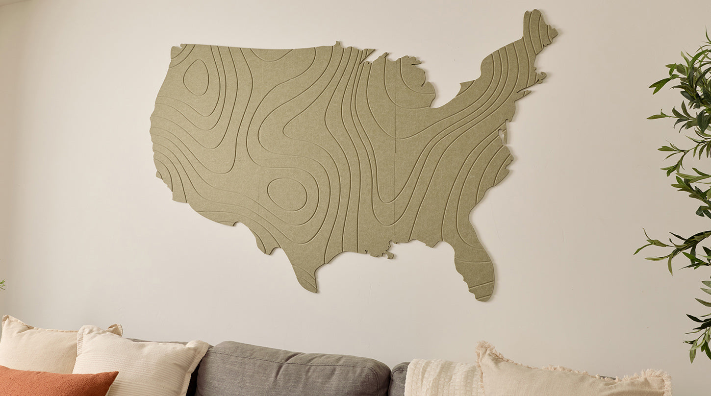 Acoustic felt wall art of the United States on a white wall above a sofa.