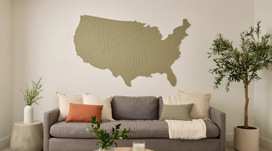 Living room with a gray sofa, decorative pillows, and a large wall map of the United States.