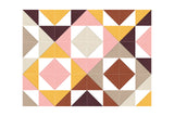Geometric patchwork pattern with triangles and diamonds in rust, gold, pink, brown, and cream tones.
