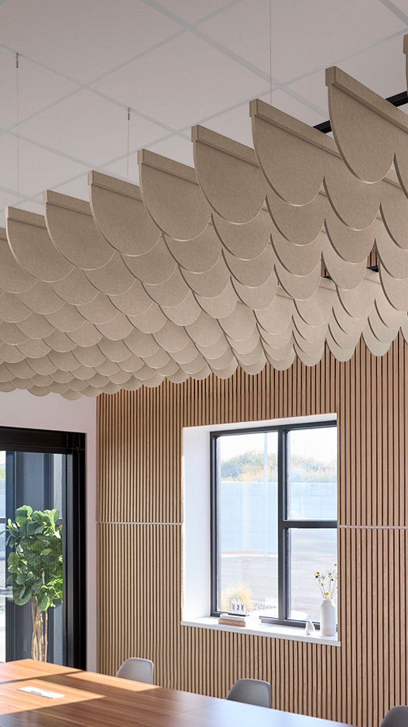 Creamy beige acoustic ceiling blade baffles suspended from the ceiling, installed in a conference room. Felt Right's acoustic blade baffles absorb 65% of sound waves, making office spaces quieter and feel more calm.