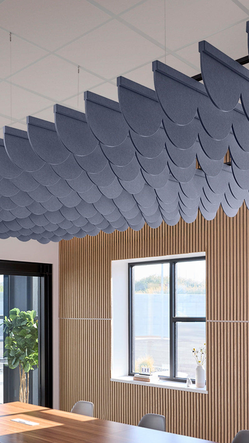 indigo blue acoustic ceiling blade baffles suspended from the ceiling, installed in a conference room. Felt Right's acoustic blade baffles absorb 65% of sound waves, making office spaces quieter and feel more calm.