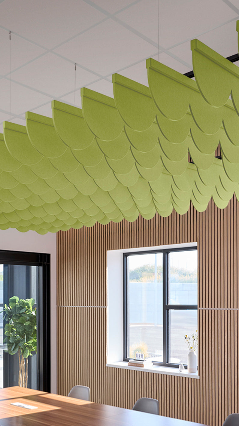 Lime green acoustic ceiling blade baffles suspended from the ceiling, installed in a conference room. Felt Right's acoustic blade baffles absorb 65% of sound waves, making office spaces quieter and feel more calm.