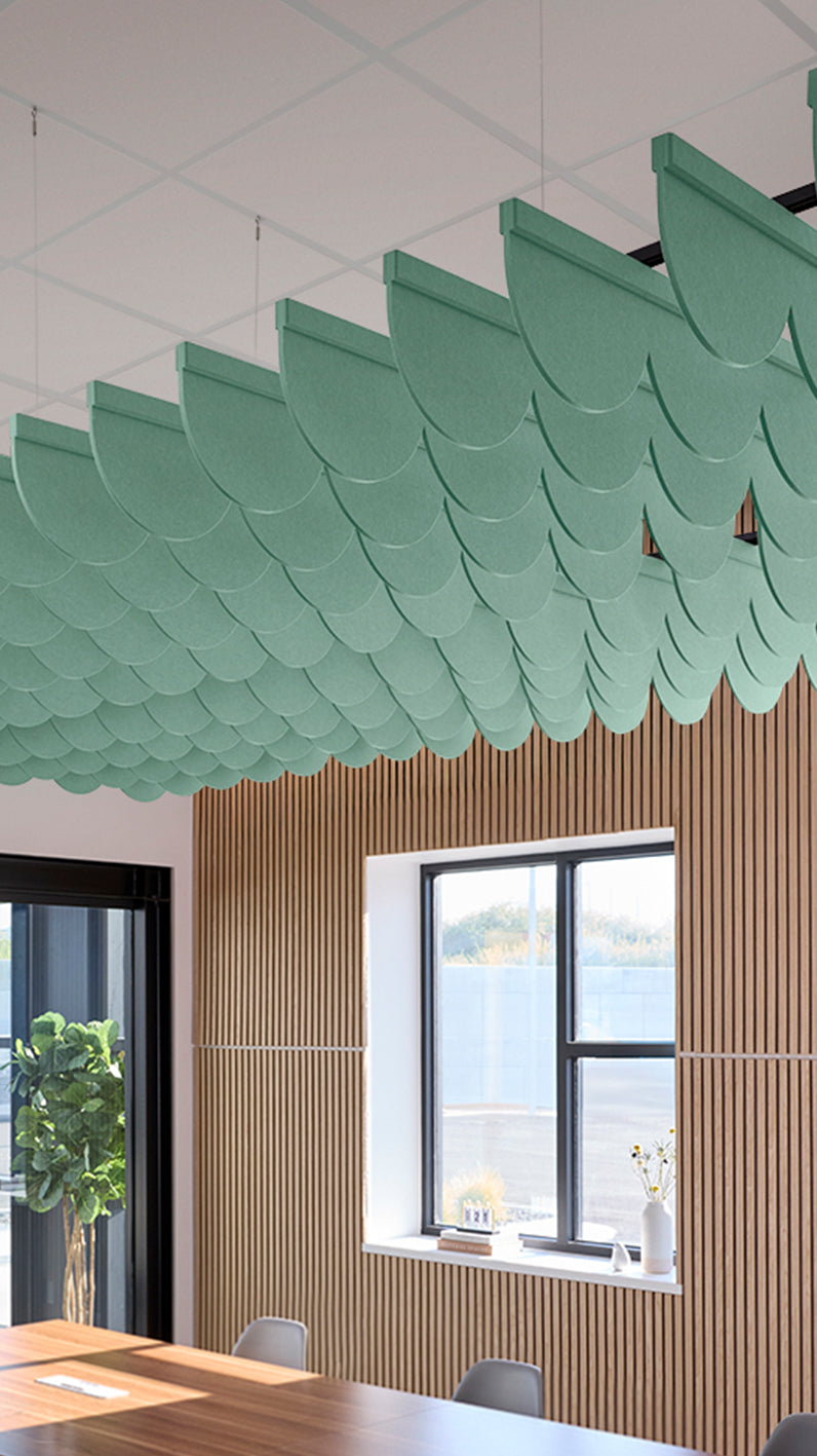 Mint green acoustic ceiling blade baffles suspended from the ceiling, installed in a conference room. Felt Right's acoustic blade baffles absorb 65% of sound waves, making office spaces quieter and feel more calm.