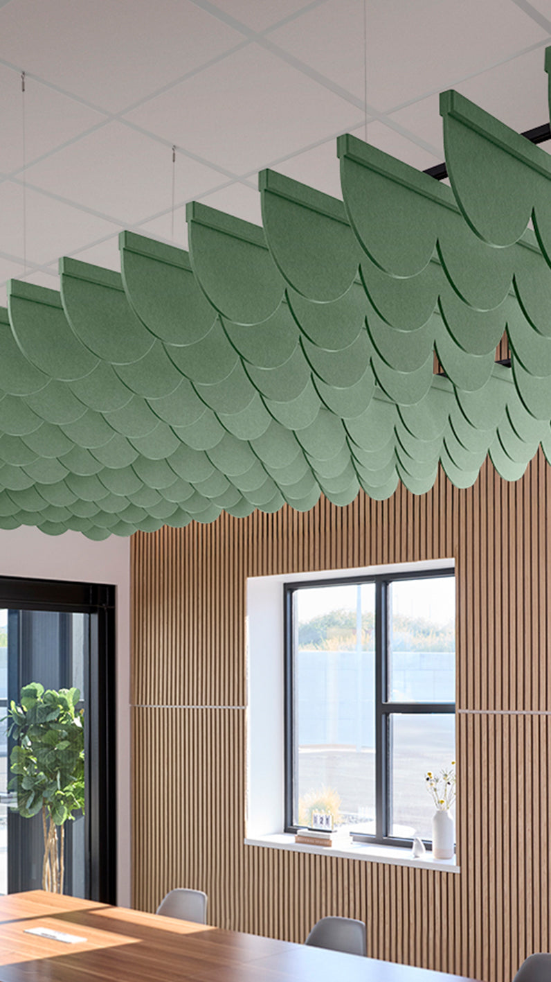 Green acoustic ceiling blade baffles suspended from the ceiling, installed in a conference room. Felt Right's acoustic blade baffles absorb 65% of sound waves, making office spaces quieter and feel more calm.