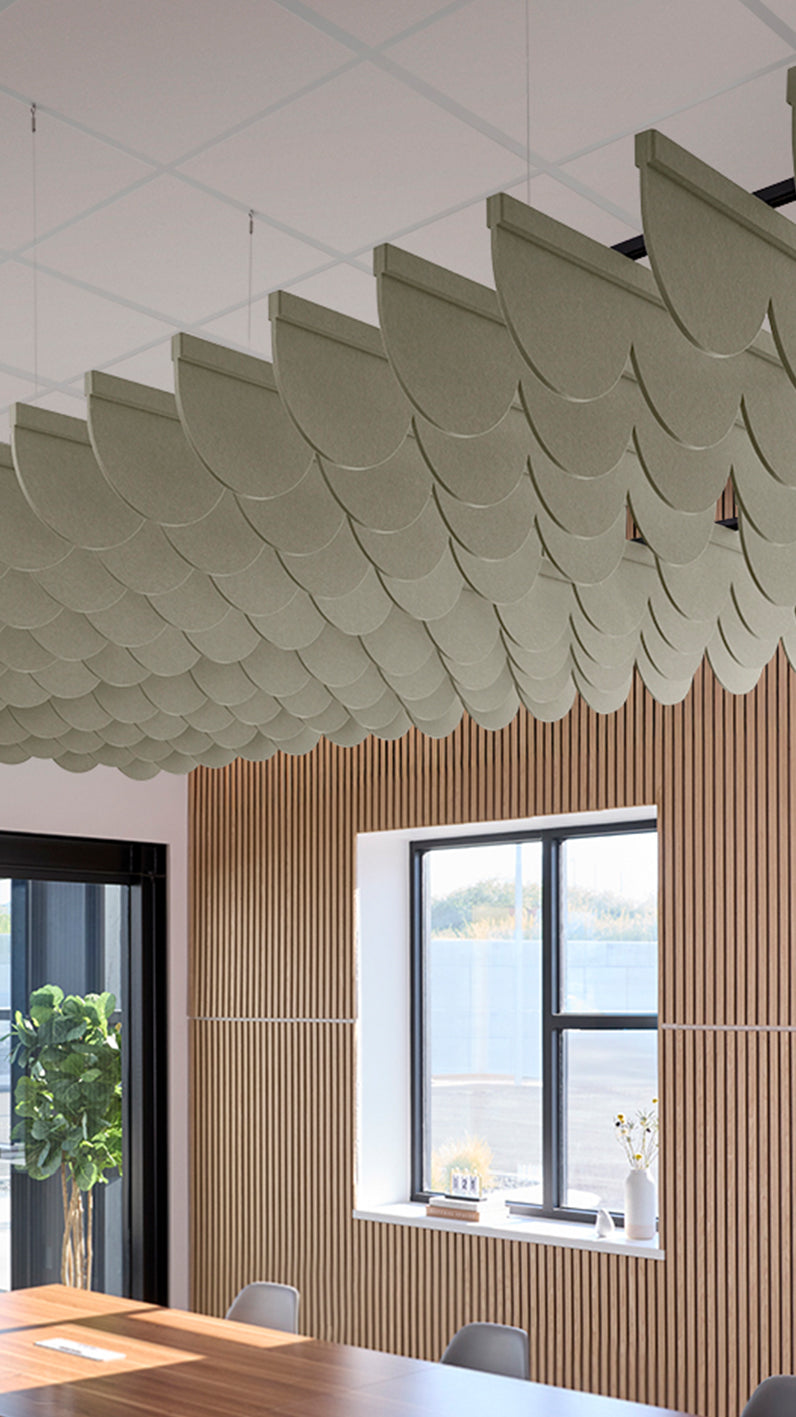 Soft green acoustic ceiling blade baffles suspended from the ceiling, installed in a conference room. Felt Right's acoustic blade baffles absorb 65% of sound waves, making office spaces quieter and feel more calm.