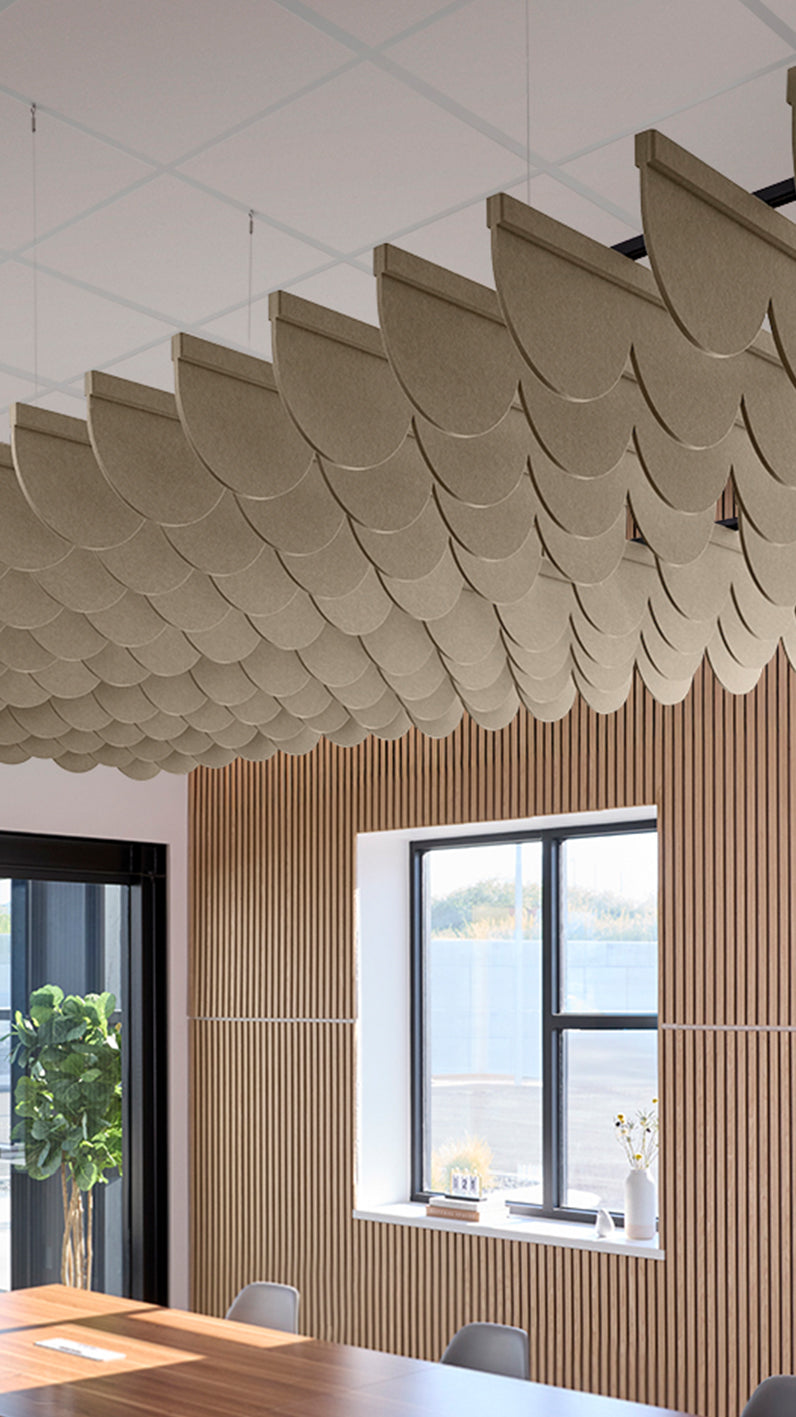 Light brown acoustic ceiling blade baffles suspended from the ceiling, installed in a conference room. Felt Right's acoustic blade baffles absorb 65% of sound waves, making office spaces quieter and feel more calm.