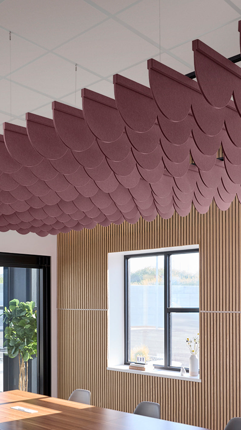 Deep reddish-purple acoustic ceiling blade baffles suspended from the ceiling, installed in a conference room. Felt Right's acoustic blade baffles absorb 65% of sound waves, making office spaces quieter and feel more calm.