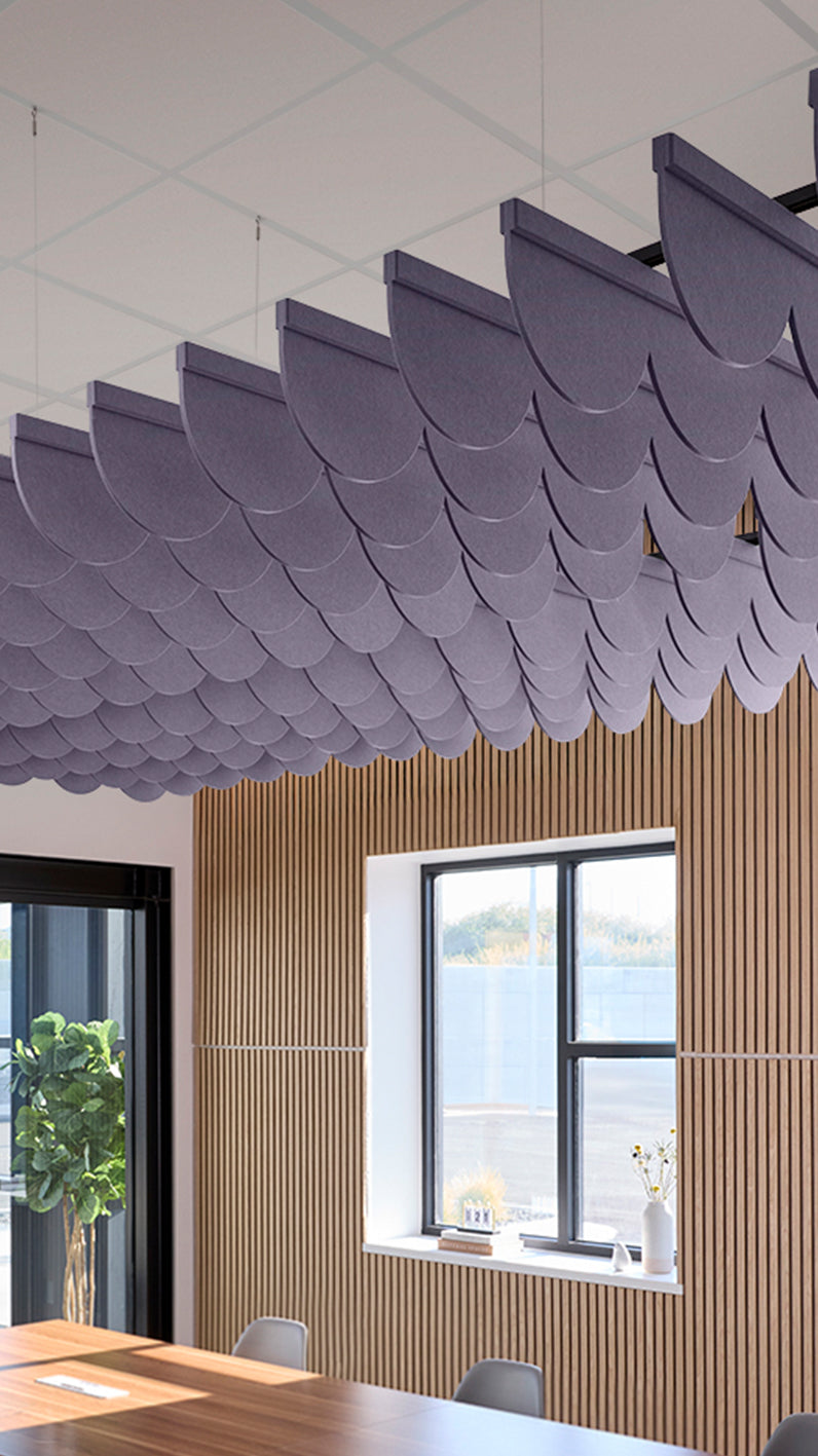 Soft violet acoustic ceiling blade baffles suspended from the ceiling, installed in a conference room. Felt Right's acoustic blade baffles absorb 65% of sound waves, making office spaces quieter and feel more calm.