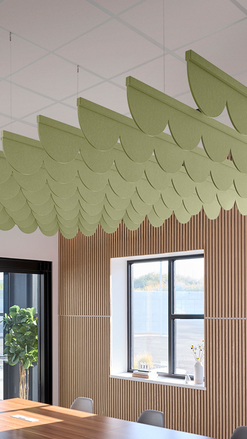 Light green acoustic ceiling blade baffles suspended from the ceiling, installed in a conference room. Felt Right's acoustic blade baffles absorb 65% of sound waves, making office spaces quieter and feel more calm.
