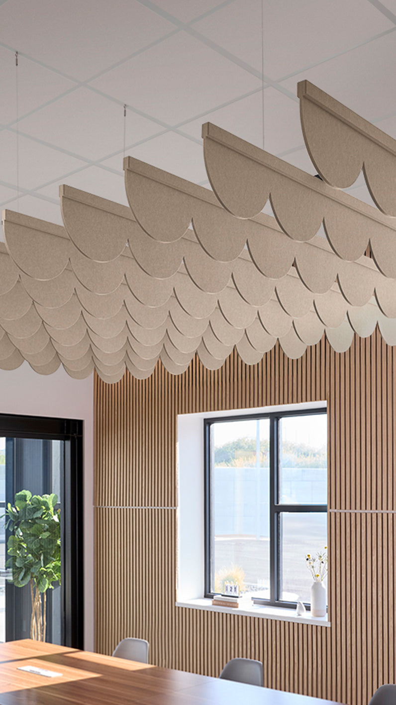 Creamy beige acoustic ceiling blade baffles suspended from the ceiling, installed in a conference room. Felt Right's acoustic blade baffles absorb 65% of sound waves, making office spaces quieter and feel more calm.