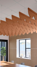 Dark orange acoustic ceiling blade baffles suspended from the ceiling, installed in a conference room. Felt Right's acoustic blade baffles absorb 65% of sound waves, making office spaces quieter and feel more calm.