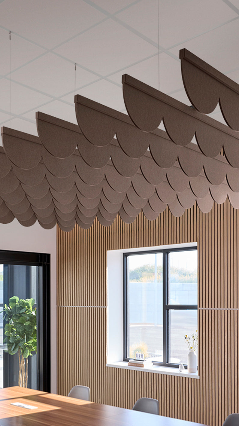 Brown acoustic ceiling blade baffles suspended from the ceiling, installed in a conference room. Felt Right's acoustic blade baffles absorb 65% of sound waves, making office spaces quieter and feel more calm.