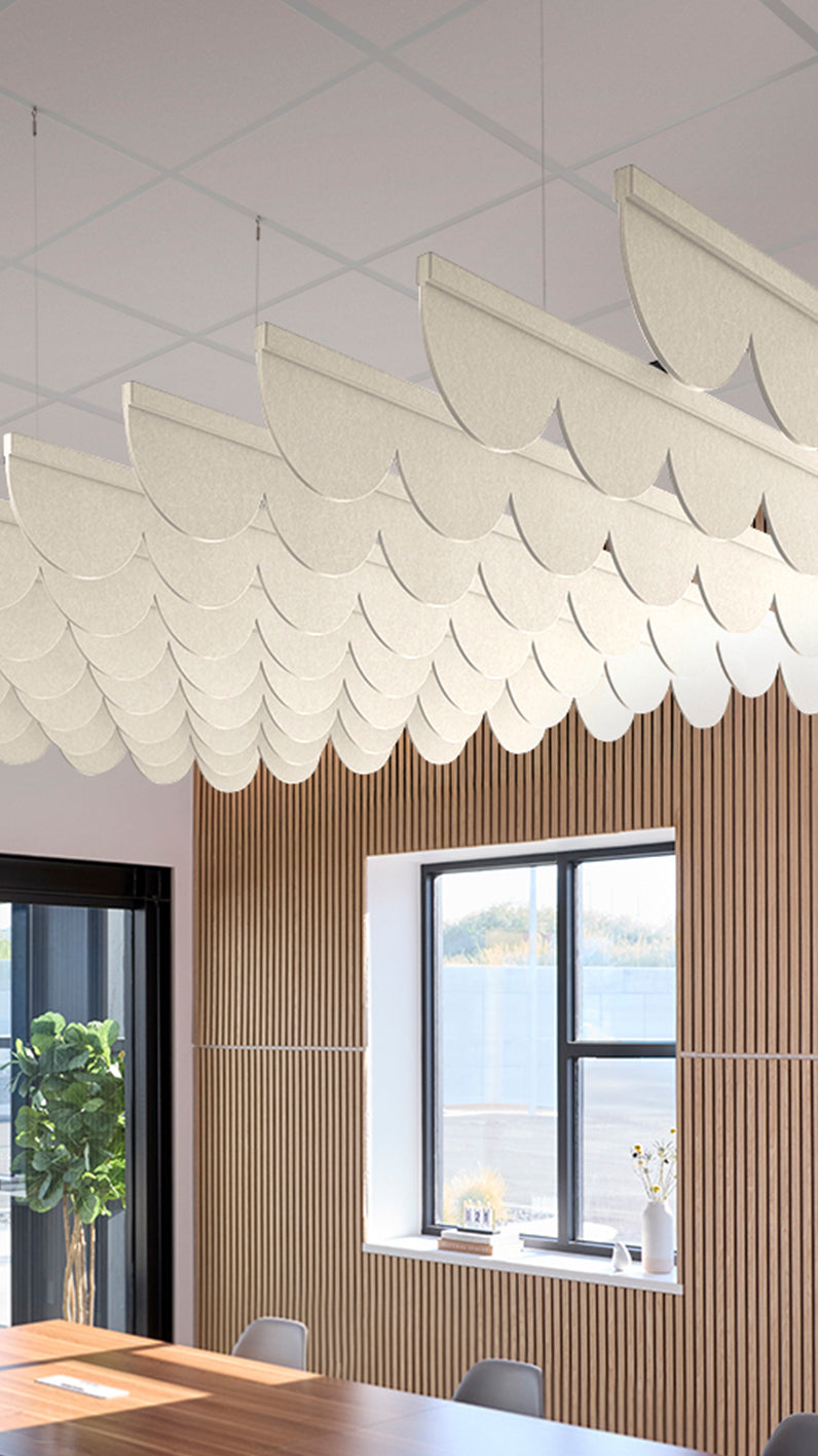 Cream acoustic ceiling blade baffles suspended from the ceiling, installed in a conference room. Felt Right's acoustic blade baffles absorb 65% of sound waves, making office spaces quieter and feel more calm.