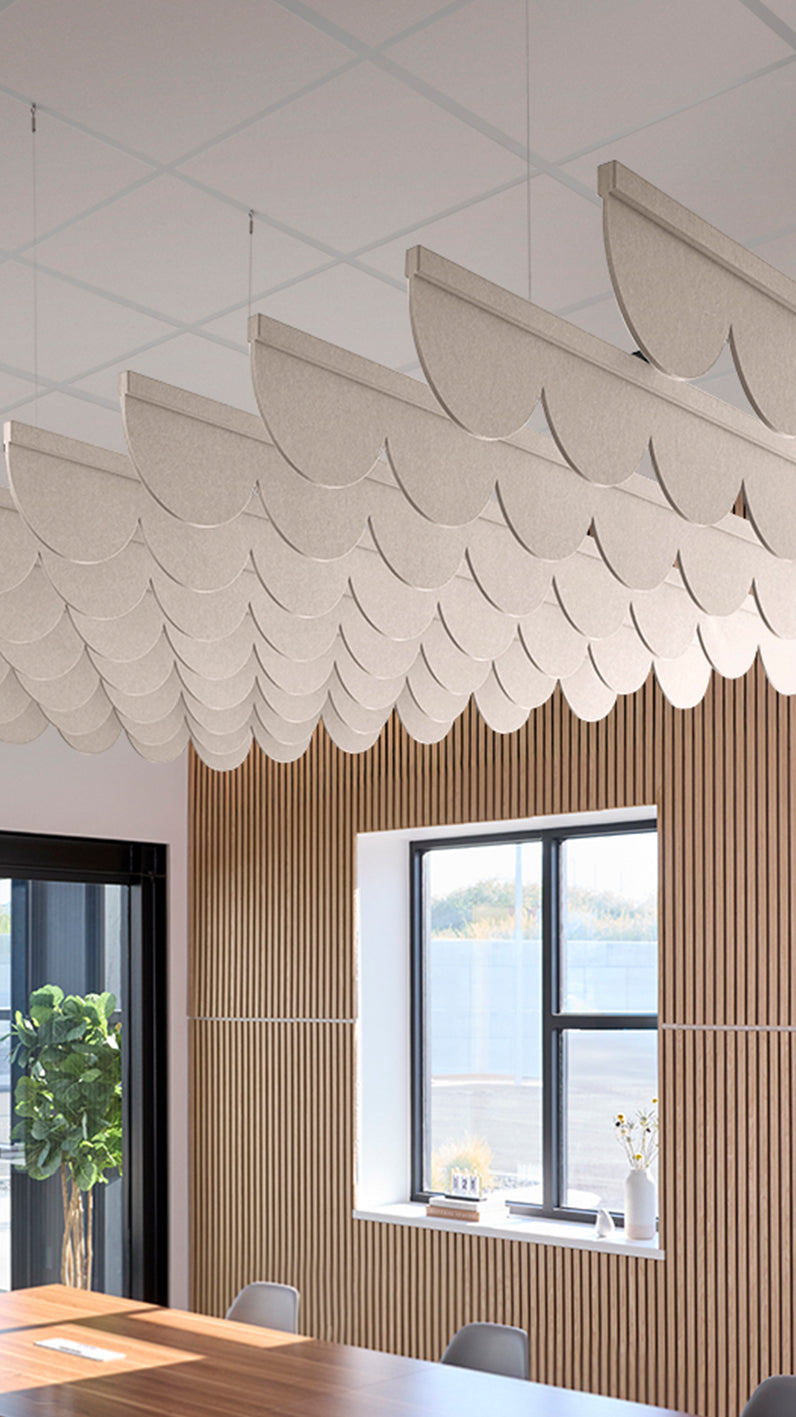 Light cream-brown acoustic ceiling blade baffles suspended from the ceiling, installed in a conference room. Felt Right's acoustic blade baffles absorb 65% of sound waves, making office spaces quieter and feel more calm.