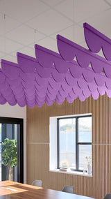 Purple acoustic ceiling blade baffles suspended from the ceiling, installed in a conference room. Felt Right's acoustic blade baffles absorb 65% of sound waves, making office spaces quieter and feel more calm.