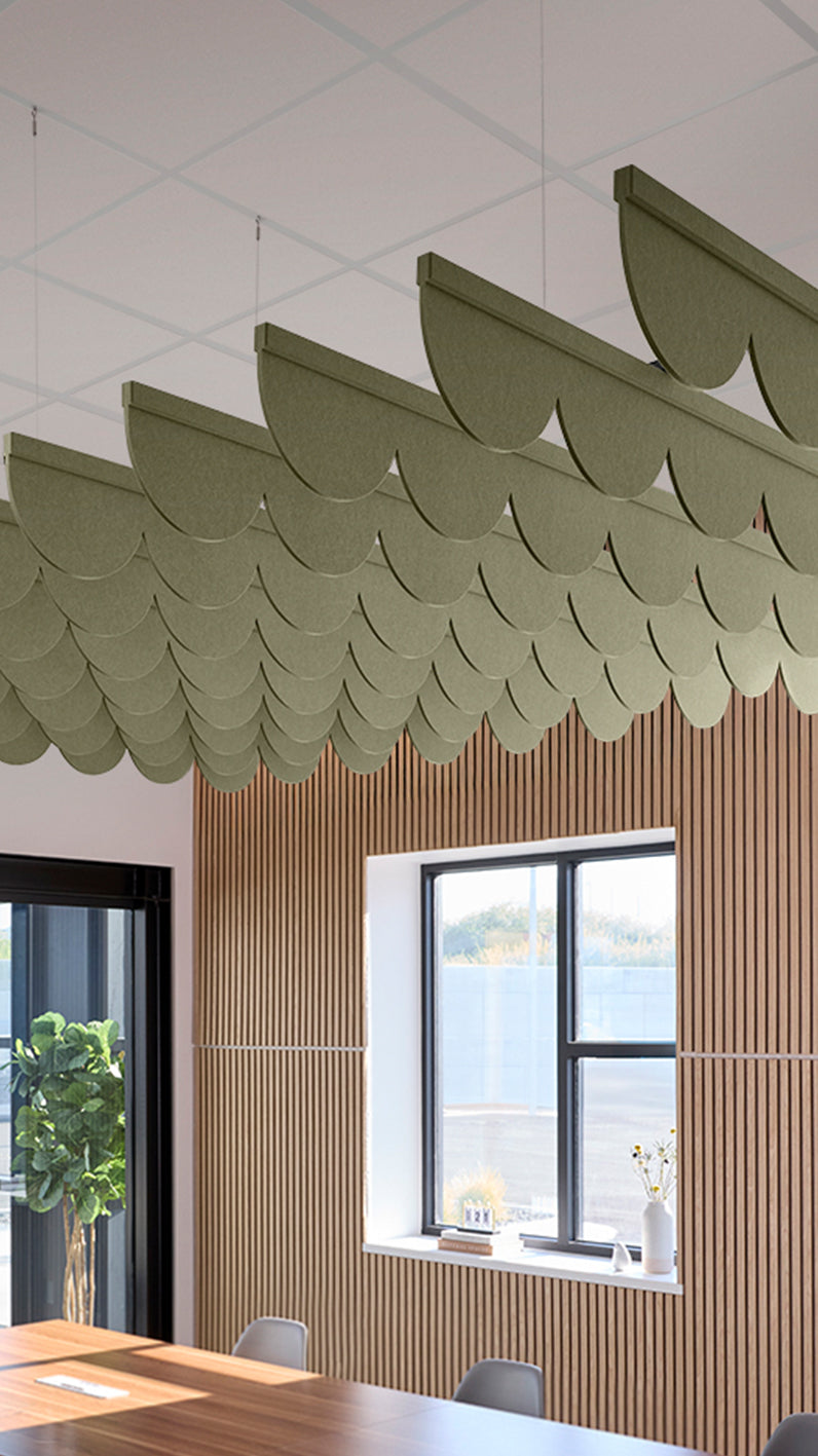 Green acoustic ceiling blade baffles suspended from the ceiling, installed in a conference room. Felt Right's acoustic blade baffles absorb 65% of sound waves, making office spaces quieter and feel more calm.