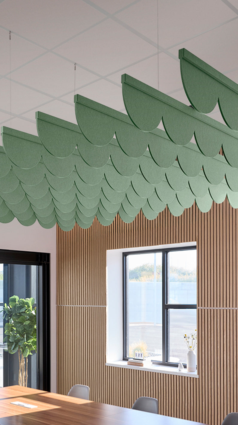 Green acoustic ceiling blade baffles suspended from the ceiling, installed in a conference room. Felt Right's acoustic blade baffles absorb 65% of sound waves, making office spaces quieter and feel more calm.