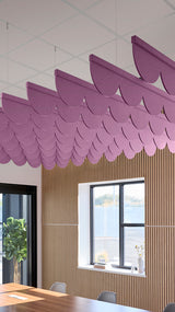Reddish-purple acoustic ceiling blade baffles suspended from the ceiling, installed in a conference room. Felt Right's acoustic blade baffles absorb 65% of sound waves, making office spaces quieter and feel more calm.