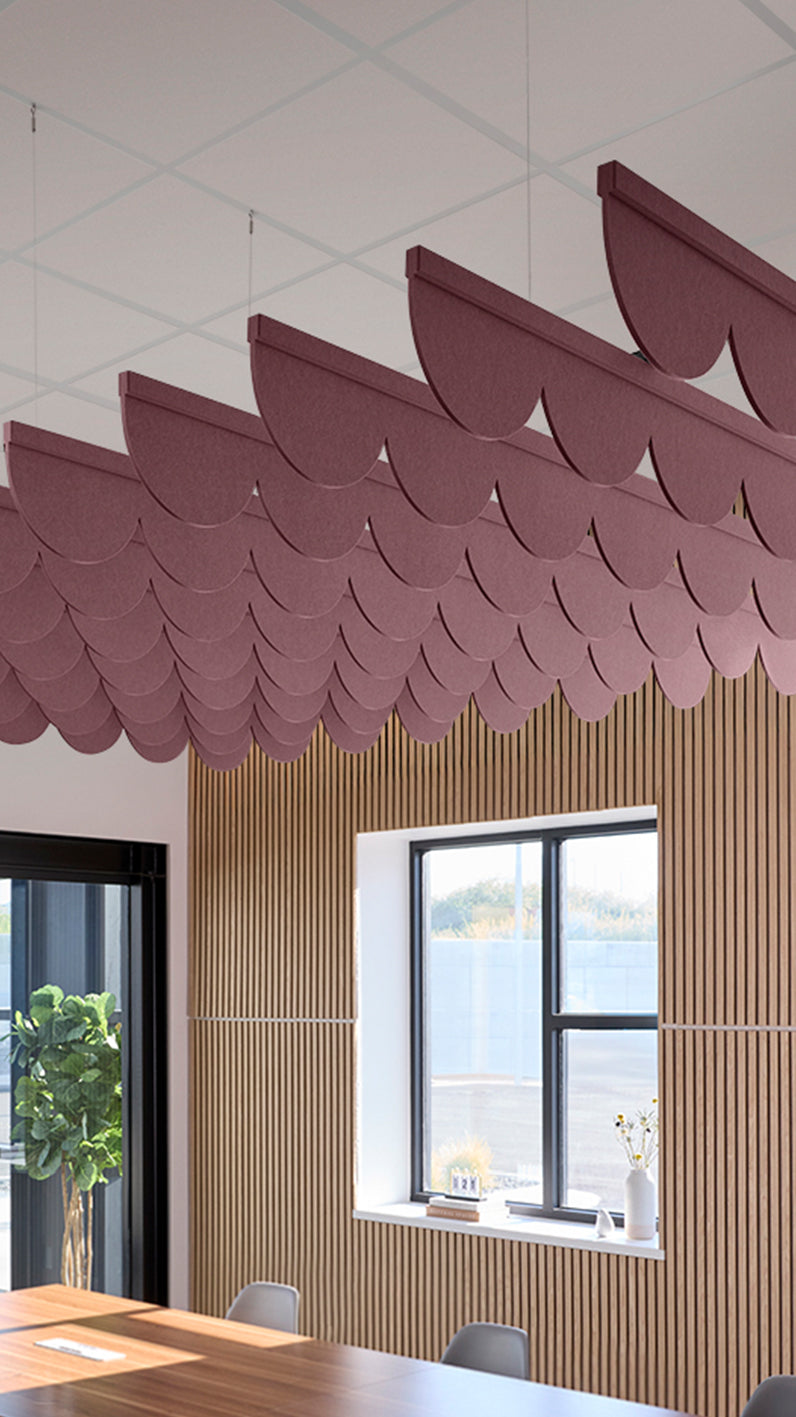 Deep reddish-purple acoustic ceiling blade baffles suspended from the ceiling, installed in a conference room. Felt Right's acoustic blade baffles absorb 65% of sound waves, making office spaces quieter and feel more calm.