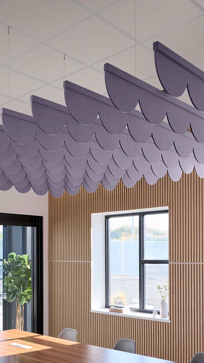 Soft violet acoustic ceiling blade baffles suspended from the ceiling, installed in a conference room. Felt Right's acoustic blade baffles absorb 65% of sound waves, making office spaces quieter and feel more calm.