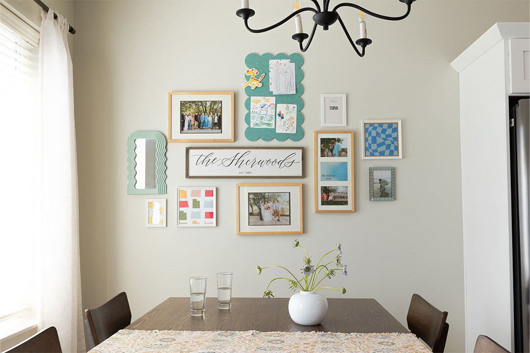 Dining room with a wall of framed pictures and a table set for four.