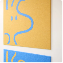 Yellow and blue abstract canvas art with curved wavy lines on wooden wall.