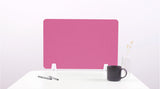 Pink desk divider with rounded corners mounted on white desk with two pens, dark mug, and white vase visible.