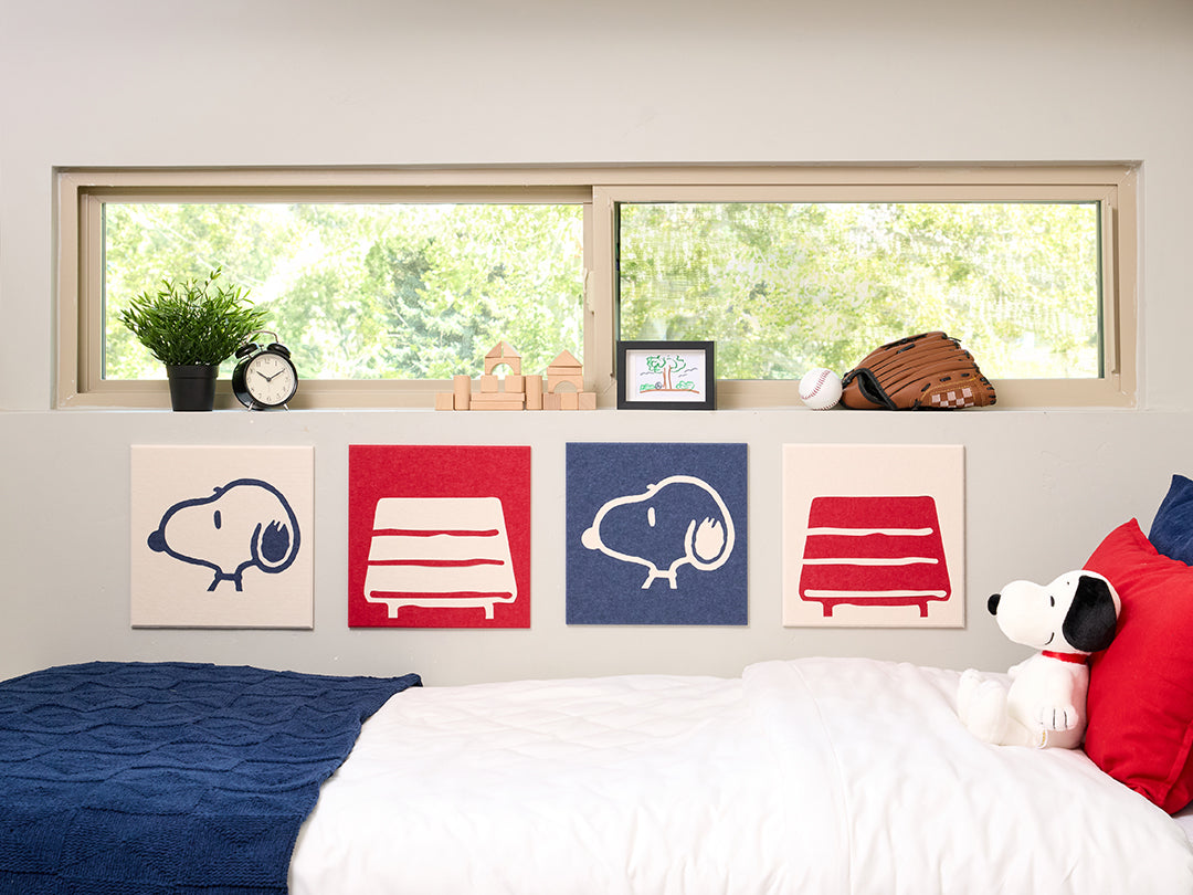 Bedroom with Snoopy plush toy and decorative pillows on a bed, featuring Snoopy illustrations on the wall.
