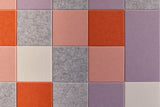 Colorful grid wall art with orange, pink, purple, and gray squares arranged in horizontal pattern.