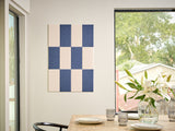 Felt Right Wall Design in a dining room with a checkered wall art piece in blue and cream and a vase of flowers on a table 
