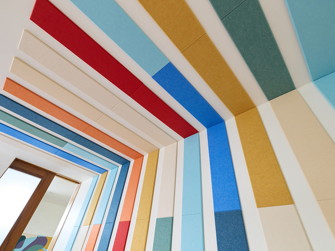 Colorful geometric pattern on a wall with a mirror reflection.