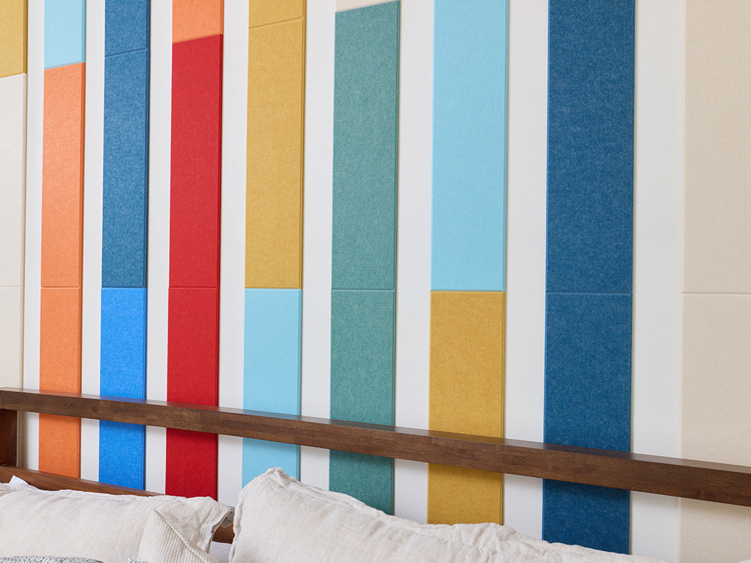 Colorful striped wall panels in a room with a bed.