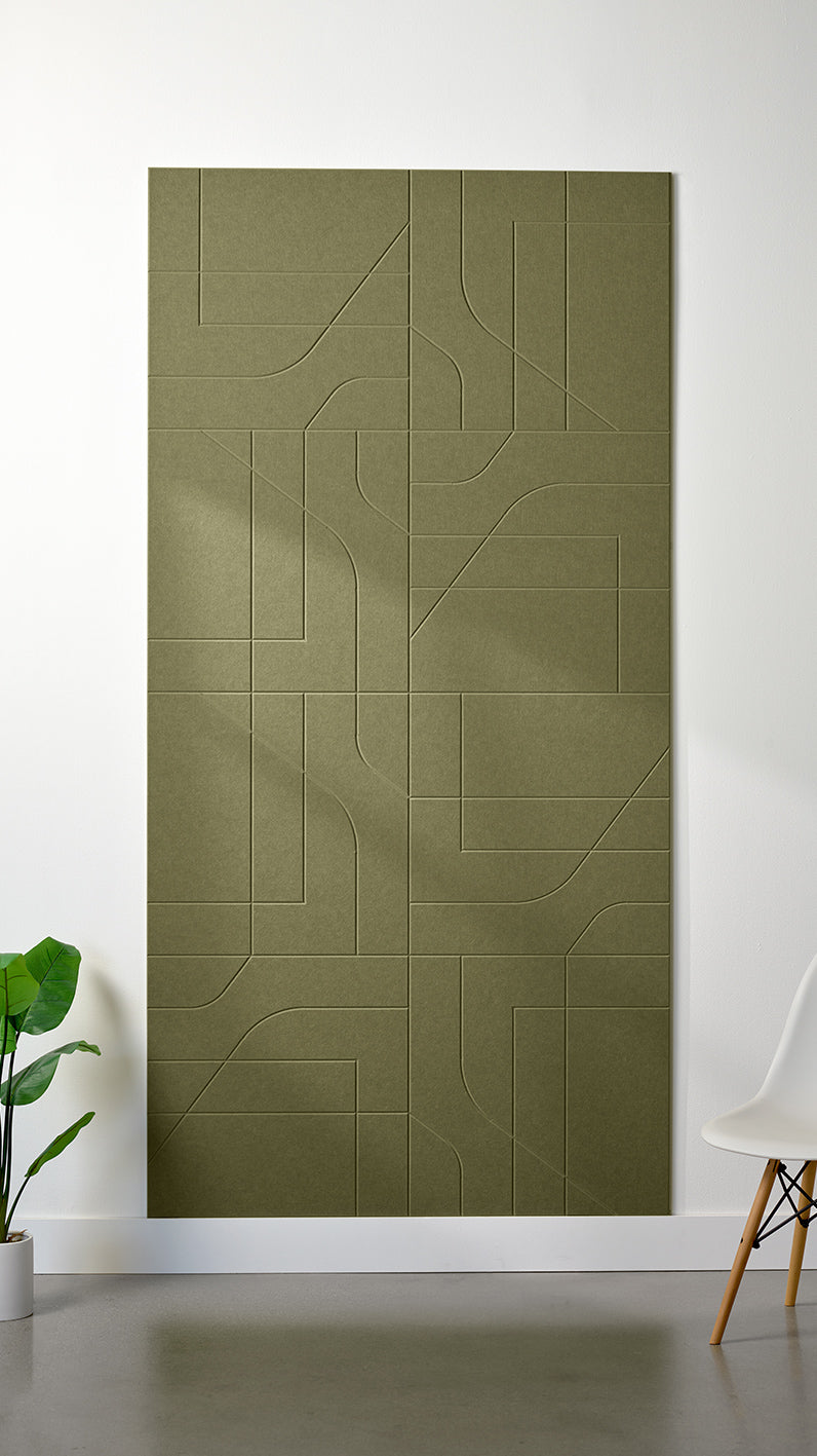 Olive green Felt Right 4’ x 8’ PET felt panel with intersecting lines similar to a transit system map engraved into the material against a white wall. A plant and chair are in the foreground.